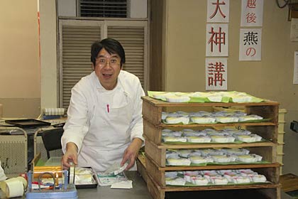 天神講の菓子のパッケージに忙しい飴屋本舗の遠藤店主