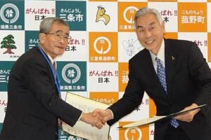 災害時の相互応援協定の協定書に調印して握手する三条市社会福祉協議会の前山会長(左)と菰野町社会福祉協議会の小林会長(右)