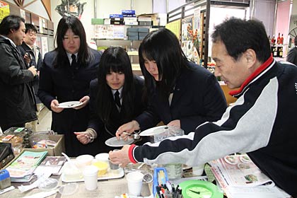 まちなか応援サポーターとして三条中心市街地エリア情報紙「まんなか」の取材で山重酒店を訪れた三条商業高校商業クラブの生徒3人、ひとまず取材より試食に熱中