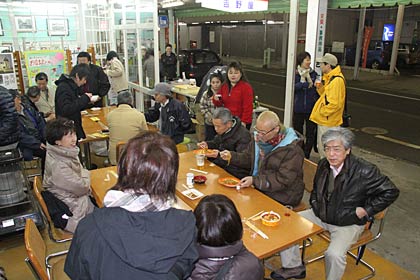  交流缶の向かいではカリーナなど食べ物や酒の販売