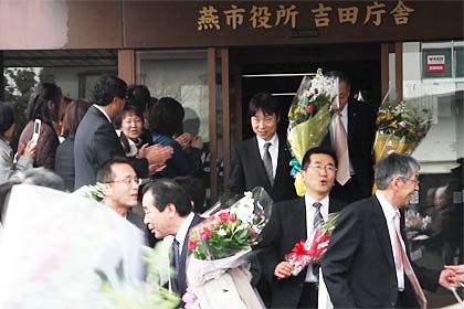 市役所を出る退職者