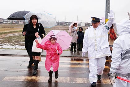 自ら手を上げて横断歩道の渡り方を指導する小林署長(右)