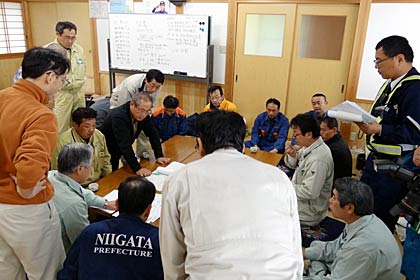 23日午前7時前から三条市牛野尾ふれあいセンターで開かれた現地対策本部の会議