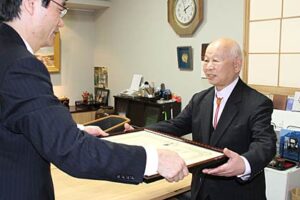 鈴木燕市長から褒章の伝達を受ける大山治郎さん(右)