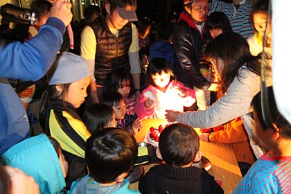 ホールケーキをデコレーションする子どもたち
