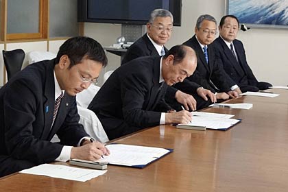 調印書にサインする国定市長（いちばん左）と大原支部長（左から2番目）