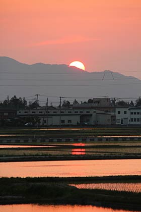 21日、燕市道金地内から空を赤く染めて国上山の向こうに沈む夕日