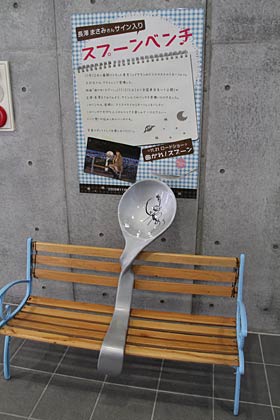 コブラの隣りに展示するのは長澤まさみのサイン入りの映画『曲がれ！スプーン』PR用スプーンベンチ