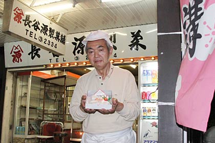 初めて吉田天満宮の大祭にあわせて天神講の菓子を販売している長谷源製菓舗の長谷川店主と右に燕市が作った天神講の菓子をPRするのぼり旗