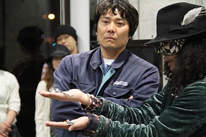 25日行われた燕市産業史料館の夜間開館、peaceさんのスプーン曲げを不安そうな顔で見詰める山崎金属工業工場長の山崎さん、右手に乗っているのが同社の「コブラ」