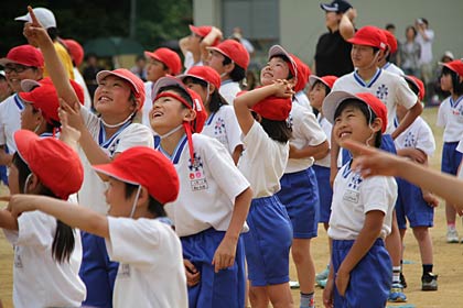笑顔で風船を見送る児童