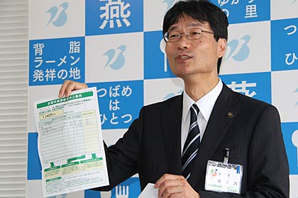 30日の定例記者会見で差額通知のサンプルを紹介する鈴木力燕市長