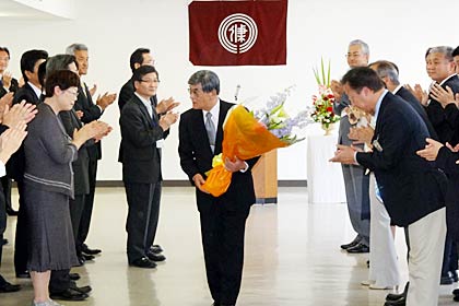  職員から花束を受け取って会場を後にする松永教育長