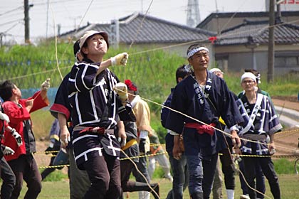 真剣な表情で凧の挙動や風を読みながら凧を操る揚げ師