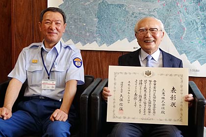 平成24年度全国危険物安全大会で優良危険物関係事業所表彰を受けた三恵(株)の外山社長(右)と市川三条市消防長(左)