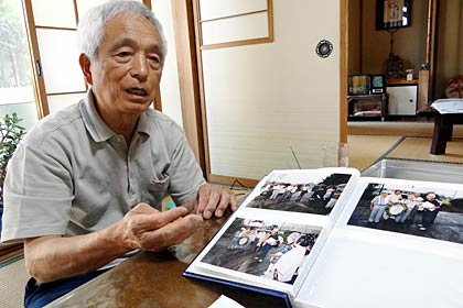 三高校舎取り壊しのときに撮影した写真のアルバムを前に話す南四日町一、二丁目自治会の上石貞夫会長