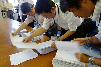 署名簿の冊数を数える選管事務局職員