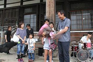 9日の三条マルシェで20万人目となった燕市の長沼さん家族に国定市長から花束を贈呈
