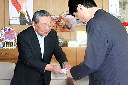 第4回会頭杯ゴルフ大会のチャリティーなどで集まった10万円を鈴木市長(右)に手渡す山崎会頭(左)