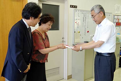  三条市社会福祉協議会の小林事務局長(右)に寄付を手渡すハーモニックの柄沢取締役(中央)と市川総務部長(左)