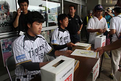 サイン会を行う旧小須戸町出身横山投手(左)と岩本投手(右)