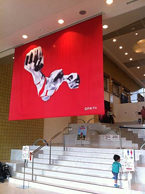 「ウルトラマン創世紀展」が開かれている新潟市新津美術館を入ってすぐ、ウルトラマンが変身するシーンの巨大なバナーが下がる