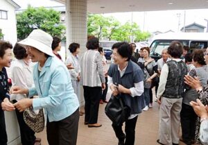 1年ぶりに避難生活を送った三条市勤労青少年ホームを訪れた福島県南相馬市の「ソレイユ会」、「南四日町1・2丁目熟年いこいの会」の歓迎を受ける