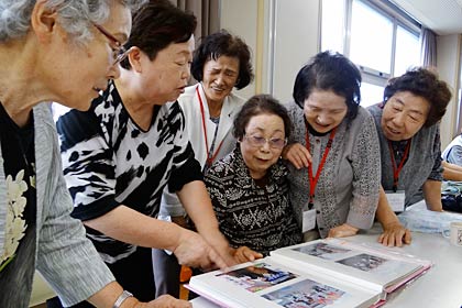 写真アルバムを広げて避難当時を振り返る