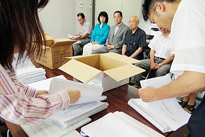  署名簿なと?必要書類を確認する監査委員会事務局職員