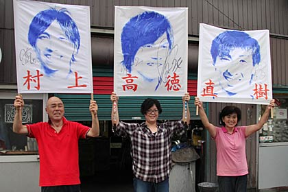 アルビレックス新潟ファンの川崎さん一家、希代美さん作のゲーフラを掲げて左から父の栄治さん、希代美さん、母千賀子さん