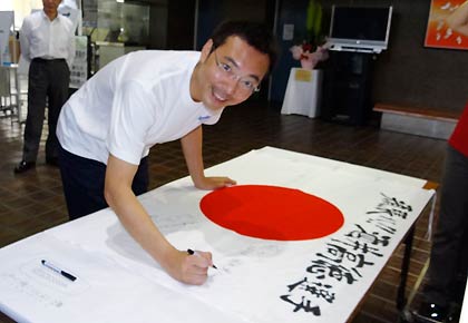  ロンドン五輪男子サッカー日本代表に選出された三条市出身の酒井高徳選手を応援する寄せ書きに書き込む国定市長