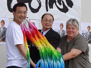 三条市が「三条マルシェ」会場でロンドン五輪男子サッカーに出場する三条市出身酒井高徳選手の応援セレモニー、国定市長(左)から酒井選手の両親に千羽鶴の贈呈