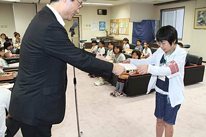  子ども記者任命式で子ども記者一人ひとりに任命書を手渡す鈴木市長