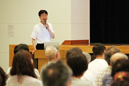 ノートパソコンに向かって施策を市民にプレゼンテーションする鈴木市長