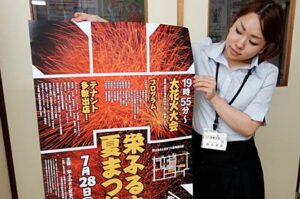 栄ふるさと夏まつりのポスターを手に実行委員会事務局の栄商工会の職員