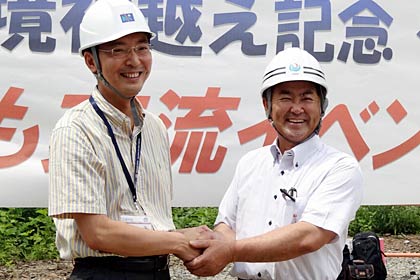 握手する国定三条市長(左)と目黒只見町長(右)