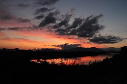  三条市上須頃地内から夕焼けでシルエットになった弥彦山とそれを映す中ノ口川の川面