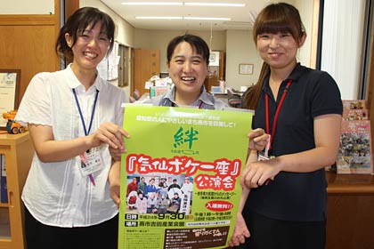 気仙ボケ一座公演会のポスターを手に分水の里職員
