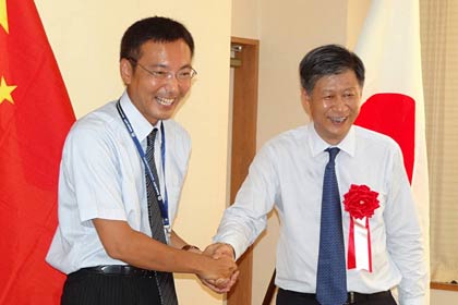  握手する国定三条市長(左)と鄂州市の韓進市長(右)