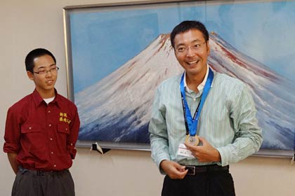 金メダルをかけておどけて見せる国定市長
