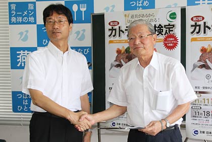 握手する鈴木市長(左)と日本金属洋食器工業組合の田中理事長