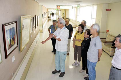 1日から済生会三条病院で開かれている宇賀治徹男&サークルみずゑ水彩画作品展で1日に展示作業を終わったあと宇賀治さんの講評を聞くサークルみずゑの会員