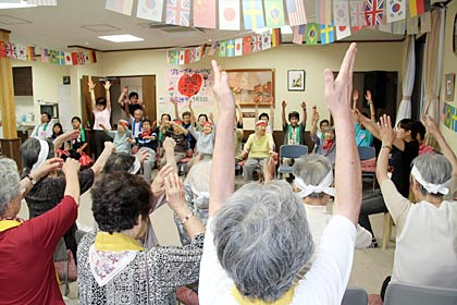 万国旗の下がる会場で鉢巻きも巻いてレインボー体操でウオーミングアップ