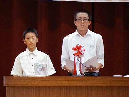 児童・生徒代表あいさつを行う一ノ木戸小6年斉藤さんと第二中修正会会長の3年兼古さん