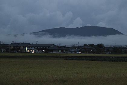11日夕方の燕市吉田地区から見る角田山はふもとを霧が隠す