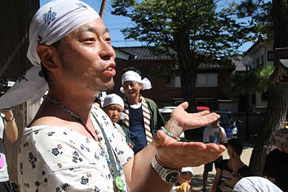 子どもたちに三本締めの意味を話す相場会長