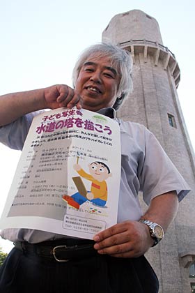 水道の塔の足元で子ども写生会「水道の塔を描こう」の申込書を手に燕市教委担当職員