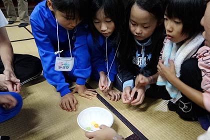 1日目の夜は1個しか食べられないあめ玉をのぞき込む子どもたち