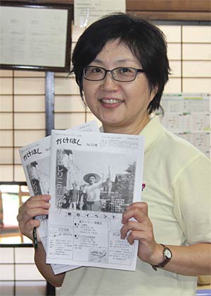 NPO法人地域たすけあいネットワークのリニューアルした会報紙「かけはし」を手に野島副理事長