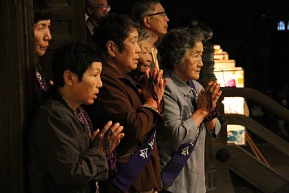 本堂から万灯に向かって手を合わせる壇信徒